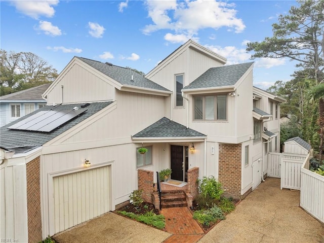 211 86th St Unit F, Virginia Beach, VA 23451 - townhome / multi-family property featuring roof with shingles, asphalt driveway, solar panels, and brick siding