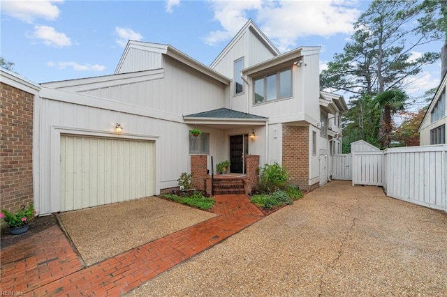 211 86th St Unit F, Virginia Beach, VA 23451 - view of front of property with an attached garage, brick siding, driveway, and a gate