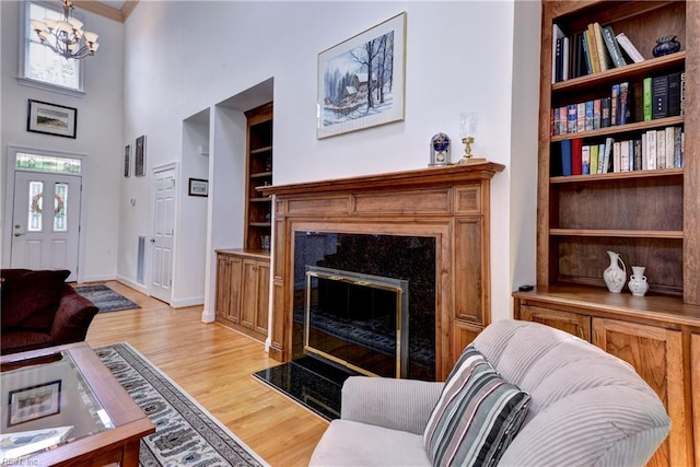 200 Cruden Bay, Williamsburg, VA 23188 - living area with a high end fireplace, light wood finished floors, healthy amount of natural light, built in features, and a towering ceiling