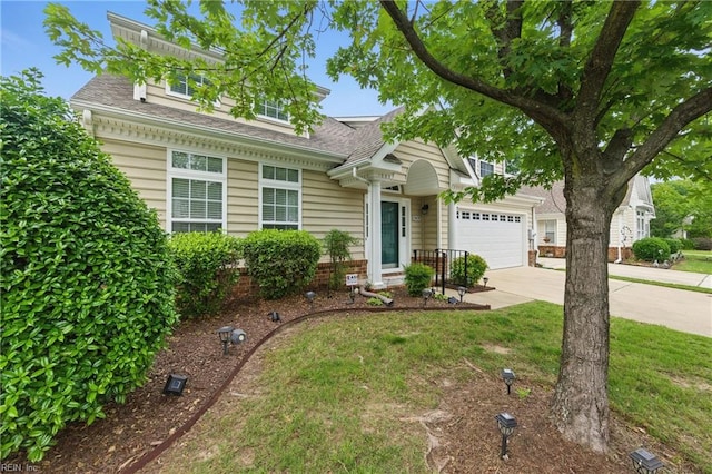 13435 Prince Andrew Trl, Carrollton, VA 23314 - view of front of house featuring concrete driveway, a garage, roof with shingles, and a front yard