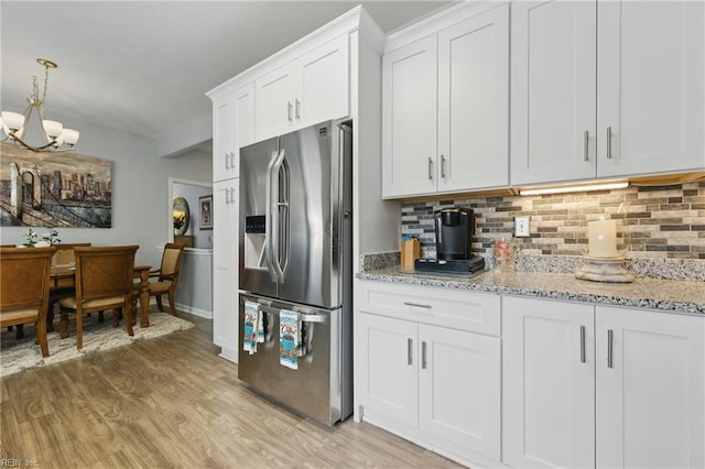 13435 Prince Andrew Trl, Carrollton, VA 23314 - kitchen with stainless steel refrigerator with ice dispenser, decorative backsplash, a chandelier, and light wood finished floors
