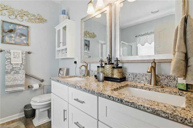 13435 Prince Andrew Trl, Carrollton, VA 23314 - bathroom with toilet, double vanity, a shower, wood finished floors, and baseboards