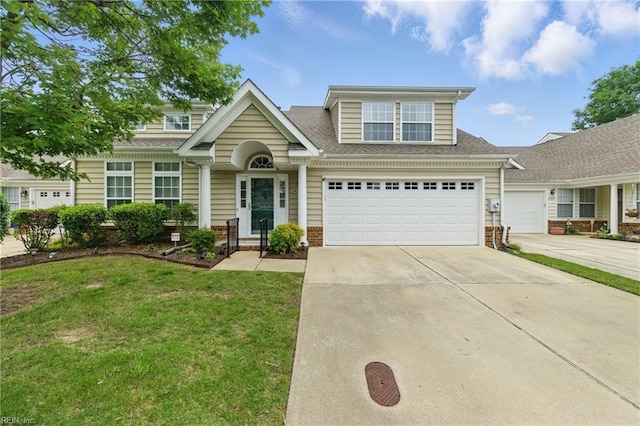 13435 Prince Andrew Trl, Carrollton, VA 23314 - traditional-style home featuring concrete driveway, a front yard, brick siding, an attached garage, and a shingled roof