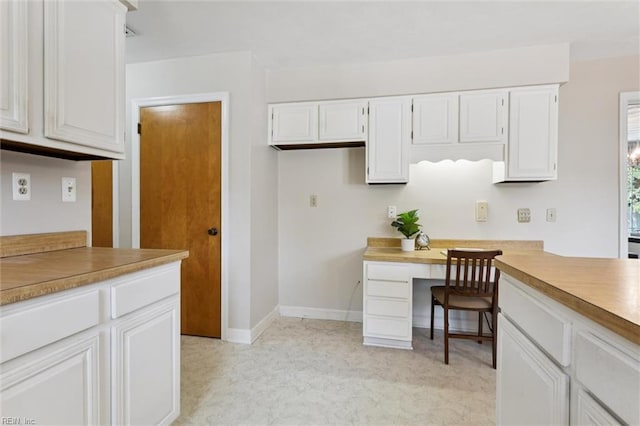 2438 Blue Castle Ct, Virginia Beach, VA 23454 - kitchen with white cabinetry, light carpet, light countertops, baseboards, and a desk