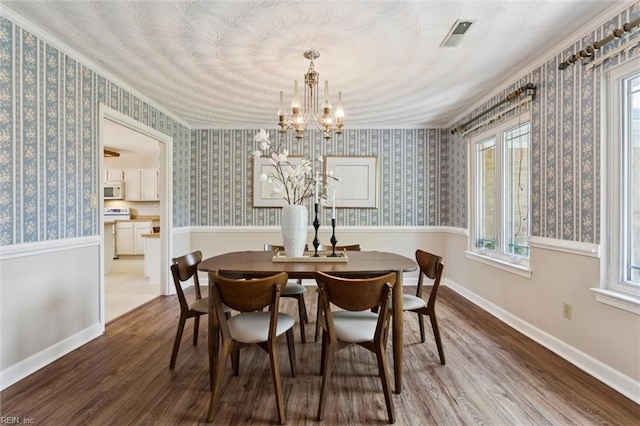 2438 Blue Castle Ct, Virginia Beach, VA 23454 - dining space with wood finished floors, a chandelier, crown molding, and wallpapered walls