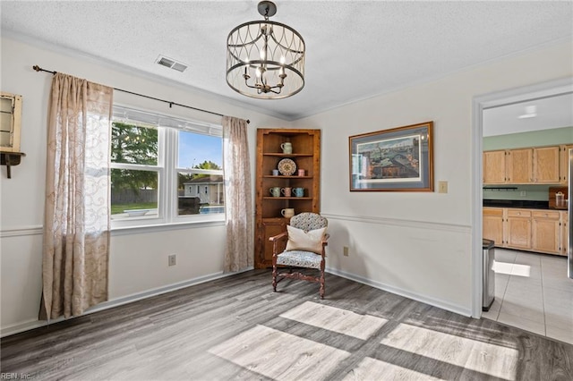 2753 Elson Green Ave, Virginia Beach, VA 23456 - living area with light wood-style flooring, a chandelier, a textured ceiling, crown molding, and baseboards