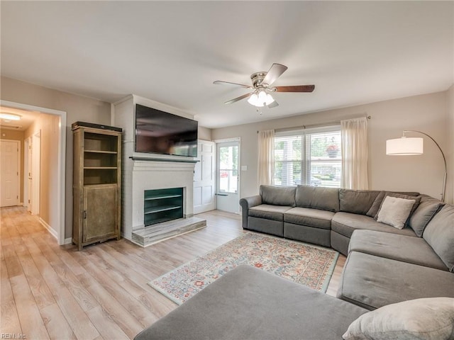 1803 Revere Dr, Hampton, VA 23664 - living room featuring ceiling fan, light wood finished floors, a fireplace with raised hearth, and baseboards