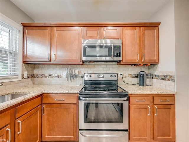 1803 Revere Dr, Hampton, VA 23664 - kitchen featuring appliances with stainless steel finishes, a sink, tasteful backsplash, and light stone countertops