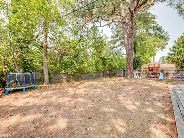 1803 Revere Dr, Hampton, VA 23664 - fenced backyard with a trampoline, a playground, and view of wooded area
