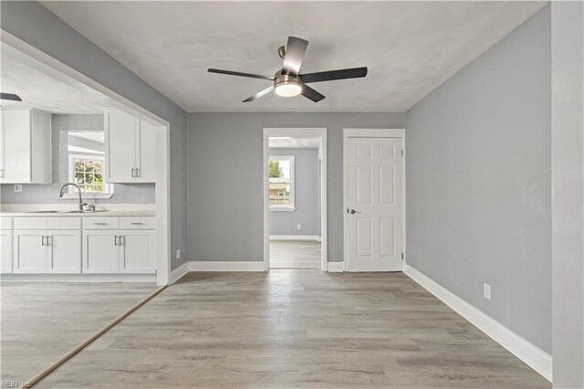 1020 Philpotts Rd, Norfolk, VA 23513 - kitchen featuring a sink, white cabinetry, light countertops, a ceiling fan, and baseboards