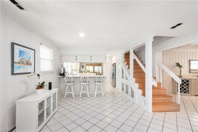 7006 Atlantic Ave, Virginia Beach, VA 23451 - dining space with stairs, light tile patterned flooring, a textured ceiling, and a baseboard radiator