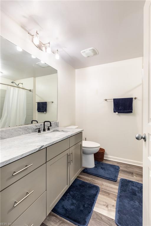 1400 Granby St Unit 413, Norfolk, VA 23510 - bathroom featuring vanity, wood finished floors, toilet, baseboards, and a shower with shower curtain