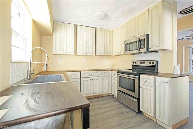 3124 Choctaw Dr, Virginia Beach, VA 23464 - kitchen featuring appliances with stainless steel finishes, cream cabinets, a sink, and plenty of natural light
