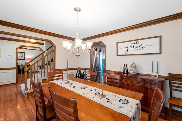 4712 Condor Dr, Chesapeake, VA 23321 - dining space with a chandelier, arched walkways, wood finished floors, a wainscoted wall, and ornamental molding