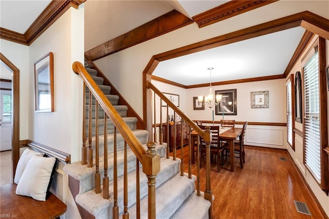 4712 Condor Dr, Chesapeake, VA 23321 - stairway featuring wood finished floors, a chandelier, ornamental molding, and a wainscoted wall