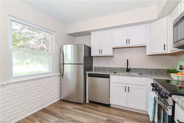 785 Biltmore Dr, Virginia Beach, VA 23454 - kitchen featuring appliances with stainless steel finishes, a sink, light stone counters, healthy amount of natural light, and a wainscoted wall