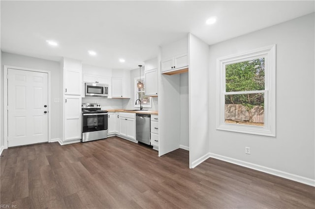 313 Delk St, Franklin, VA 23851 - kitchen with appliances with stainless steel finishes, baseboards, white cabinets, dark wood-style floors, and recessed lighting