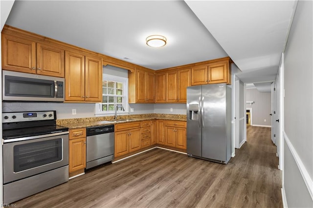 304 Odd Rd, Poquoson, VA 23662 - kitchen featuring stainless steel appliances, a sink, dark wood-style flooring, brown cabinets, and stone countertops