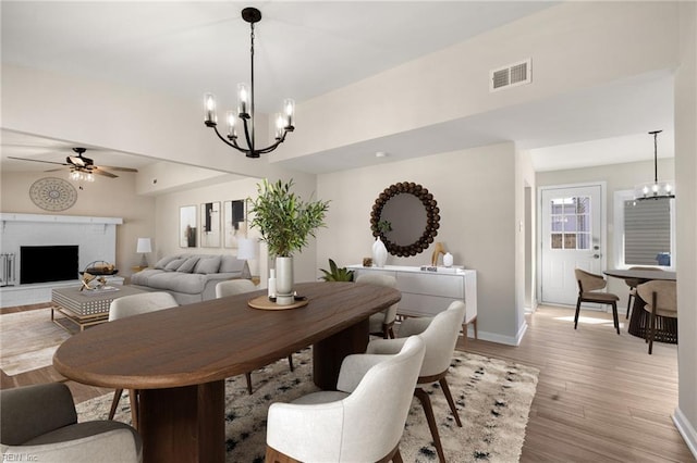 1857 Karen Ln, Virginia Beach, VA 23454 - dining area featuring a chandelier, light wood-type flooring, ceiling fan, a fireplace with raised hearth, and baseboards