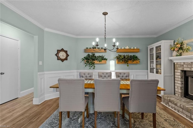 1216 New Born Ct, Chesapeake, VA 23322 - dining room featuring a chandelier, wood finished floors, a brick fireplace, ornamental molding, and a textured ceiling