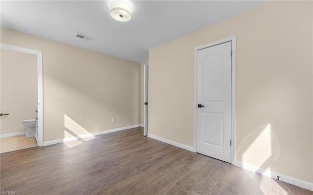 1535 Vine St, Norfolk, VA 23523 - unfurnished bedroom featuring wood finished floors, baseboards, and ensuite bathroom