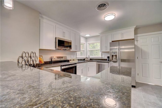 116 Odd Rd, Poquoson, VA 23662 - kitchen featuring stainless steel appliances, white cabinetry, light tile patterned flooring, and a peninsula