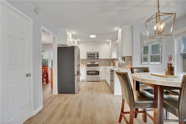 1240 Mozart Dr, Virginia Beach, VA 23454 - kitchen featuring stainless steel appliances, a sink, a chandelier, backsplash, and light countertops