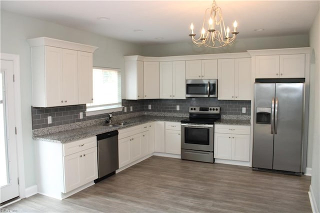 1158 Virginia Ave, Chesapeake, VA 23324 - kitchen featuring stainless steel appliances, white cabinetry, a chandelier, and decorative backsplash