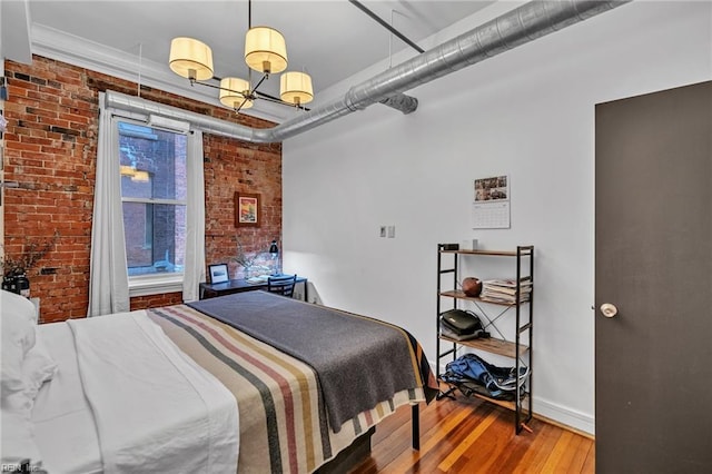 111 W Tazewell St Unit 200, Norfolk, VA 23510 - bedroom with brick wall, wood finished floors, a chandelier, and baseboards