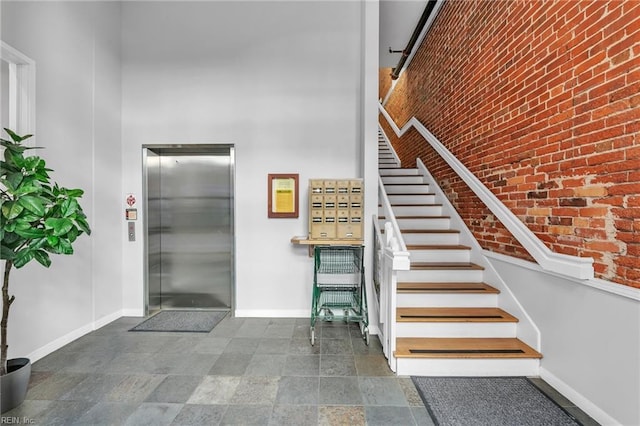 111 W Tazewell St Unit 200, Norfolk, VA 23510 - stairs featuring elevator, baseboards, a high ceiling, brick wall, and stone finish floors