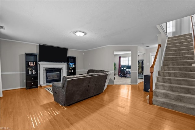 1244 Bell Tower Arch, Chesapeake, VA 23324 - living room with wood finished floors, stairs, baseboards, a glass covered fireplace, and a textured ceiling