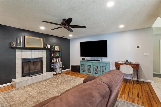 2389 Kerr Dr, Virginia Beach, VA 23454 - living room featuring a ceiling fan, baseboards, recessed lighting, a tile fireplace, and a textured ceiling