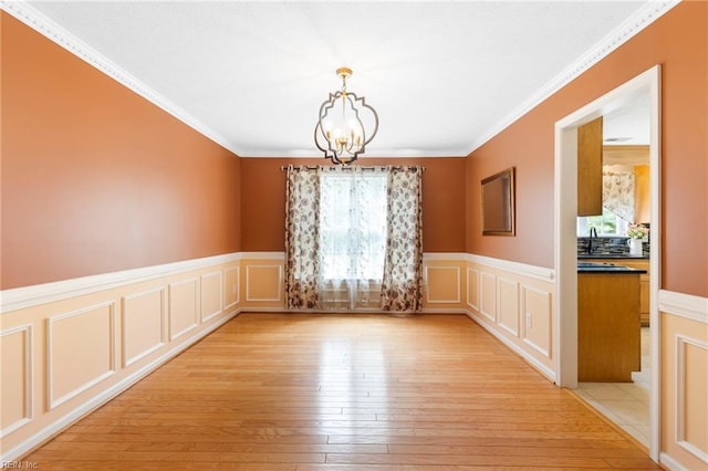 6 Elite Ct, Hampton, VA 23666 - unfurnished dining area featuring a chandelier, light wood-style flooring, wainscoting, a decorative wall, and ornamental molding
