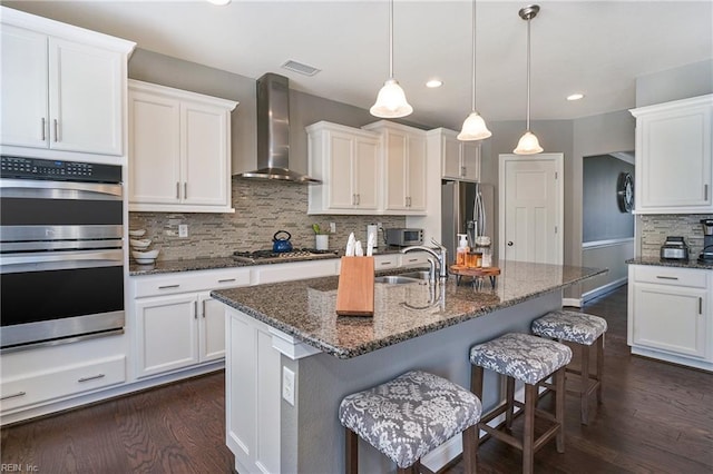 604 Baker Loop, Chesapeake, VA 23320 - kitchen featuring wall chimney range hood, stainless steel appliances, dark wood finished floors, recessed lighting, and backsplash