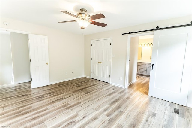 2408 Raynor Ct, Virginia Beach, VA 23456 - unfurnished bedroom featuring a barn door, light wood finished floors, baseboards, a ceiling fan, and a closet