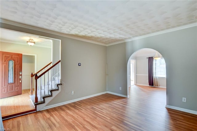 3009 Barberry Ln, Virginia Beach, VA 23453 - spare room featuring wood finished floors, arched walkways, baseboards, stairs, and crown molding