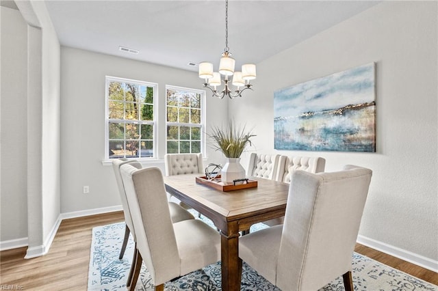 209 Apple Ct, Elizabeth City, NC 27909 - dining area with a chandelier, baseboards, and light wood-style flooring