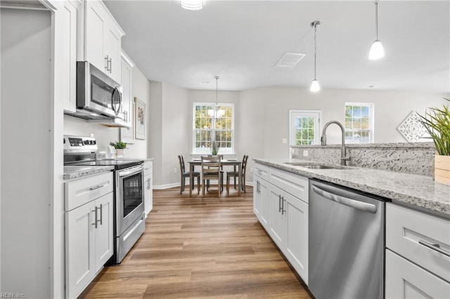 209 Apple Ct, Elizabeth City, NC 27909 - kitchen with stainless steel appliances, a sink, light wood-style flooring, white cabinets, and healthy amount of natural light