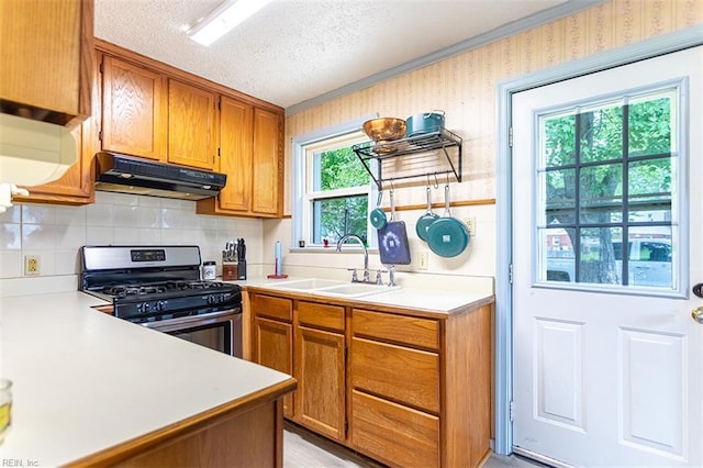 795 Old Oyster Point Rd, Newport News, VA 23602 - kitchen featuring under cabinet range hood, stainless steel range with gas stovetop, light countertops, brown cabinets, and a textured ceiling