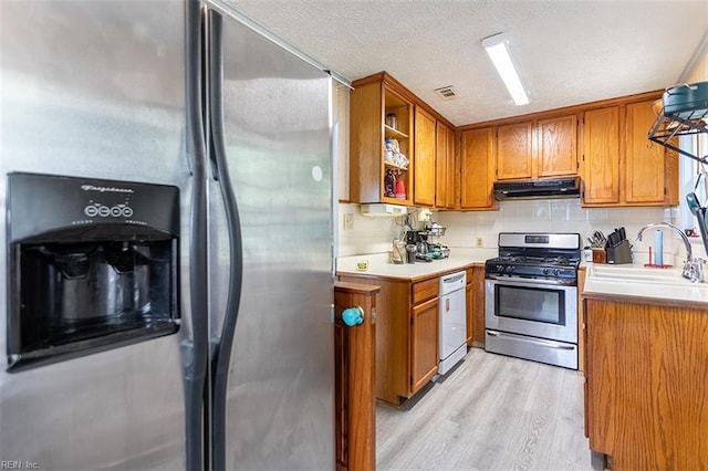 795 Old Oyster Point Rd, Newport News, VA 23602 - kitchen with stainless steel appliances, under cabinet range hood, brown cabinets, light wood-type flooring, and light countertops