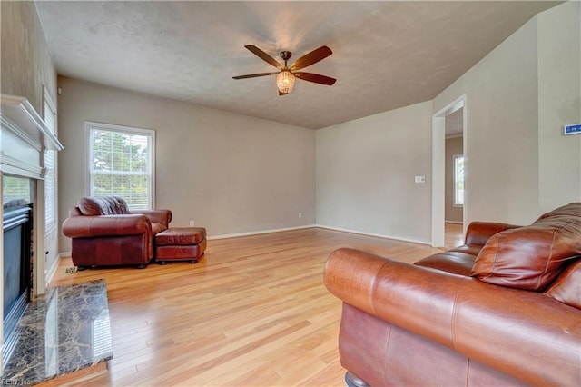 204 Goshawk Ct, Suffolk, VA 23435 - living area with a high end fireplace, ceiling fan, light wood-style floors, and baseboards