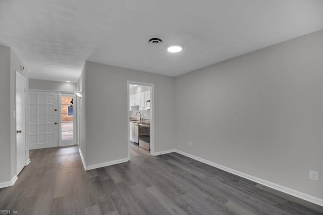 376 Merrimac Trl Unit 113, Williamsburg, VA 23185 - unfurnished room with dark wood-type flooring, baseboards, and a sink