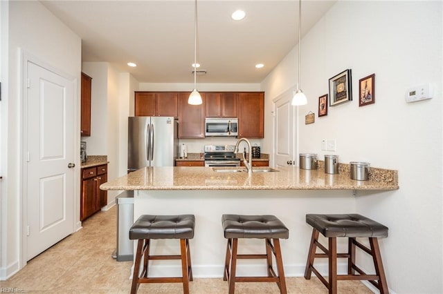 471 Abelia Way, Chesapeake, VA 23322 - kitchen featuring appliances with stainless steel finishes, a peninsula, light stone countertops, a breakfast bar, and hanging light fixtures