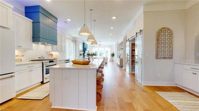 909 Jennings Ln, Chesapeake, VA 23322 - kitchen with range with gas stovetop, white refrigerator, light wood finished floors, light countertops, and recessed lighting