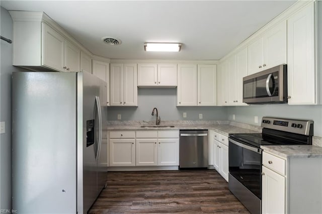 2816 N Nansemond Dr, Suffolk, VA 23435 - kitchen featuring stainless steel appliances, a sink, dark wood-style floors, white cabinetry, and light stone countertops