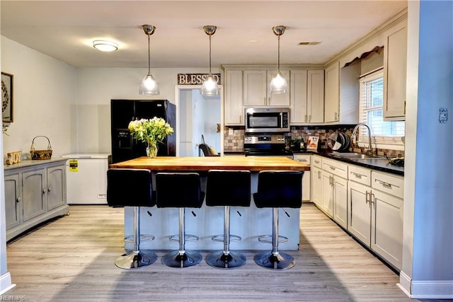 115 Bowen Dr, Hampton, VA 23666 - kitchen with butcher block countertops, appliances with stainless steel finishes, tasteful backsplash, and a kitchen island