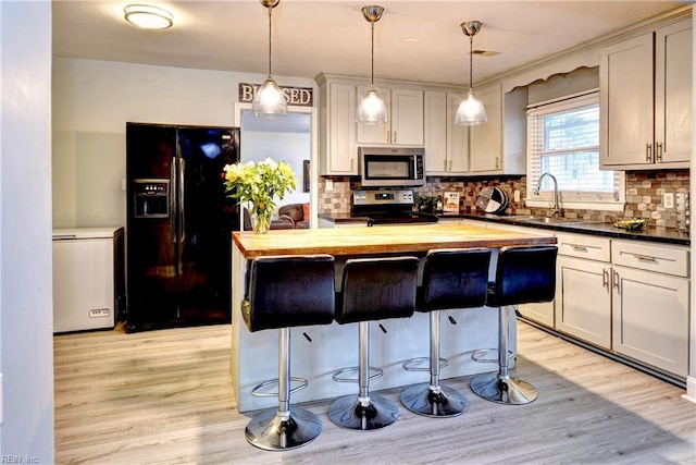 115 Bowen Dr, Hampton, VA 23666 - kitchen featuring stainless steel appliances, butcher block countertops, a kitchen island, and a kitchen breakfast bar