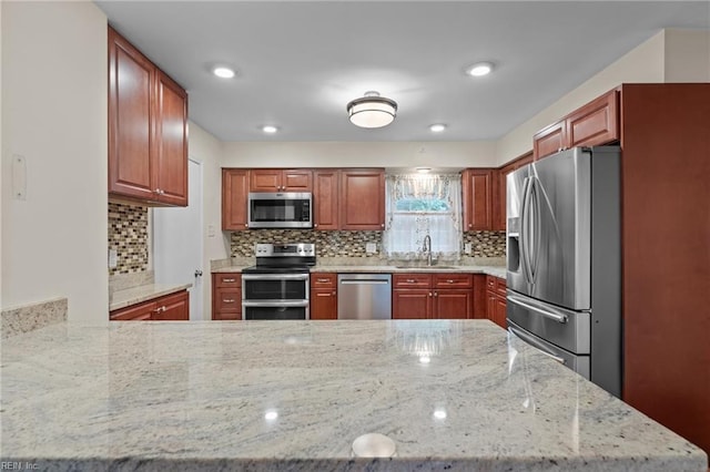 10 Kathy Dr, Poquoson, VA 23662 - kitchen with appliances with stainless steel finishes, a sink, decorative backsplash, a peninsula, and light stone countertops