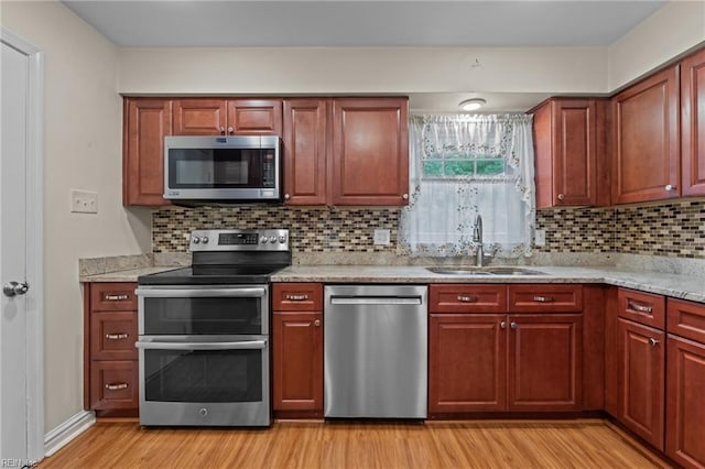 10 Kathy Dr, Poquoson, VA 23662 - kitchen with appliances with stainless steel finishes, a sink, light wood-style flooring, tasteful backsplash, and light stone counters