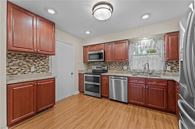 10 Kathy Dr, Poquoson, VA 23662 - kitchen featuring appliances with stainless steel finishes, a sink, light wood-style flooring, and backsplash